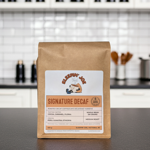 Coffee bag labeled 'Signature Decaf' by Sleepin' Joe on a kitchen counter.